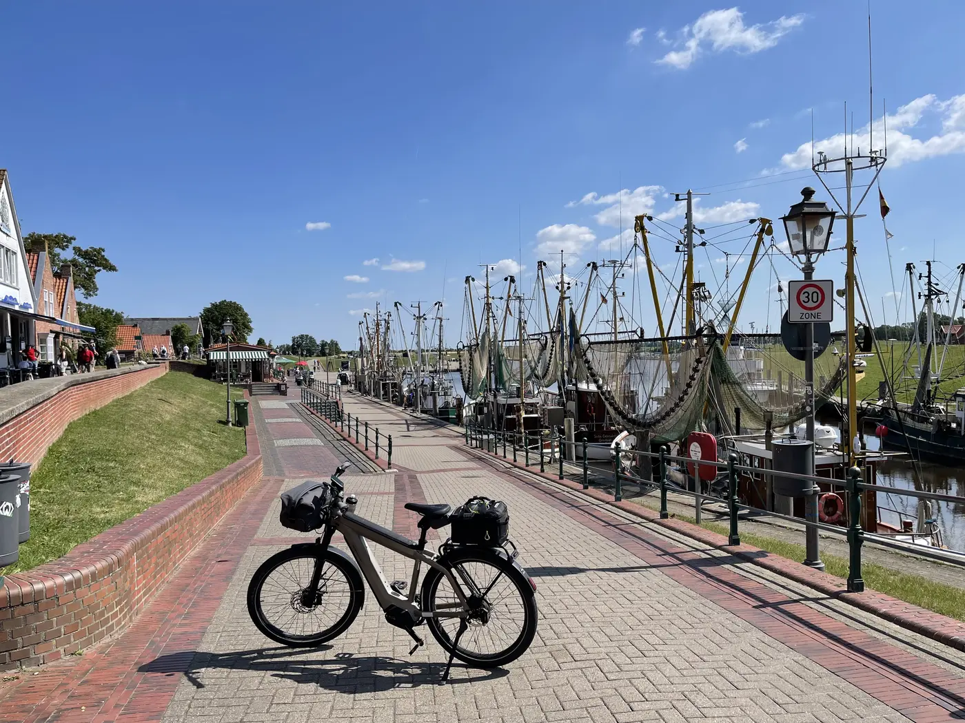 Der Hafen von Greetsiel mit Krabbenkuttern und aufgehängten Netzen, kurz vor halb neun