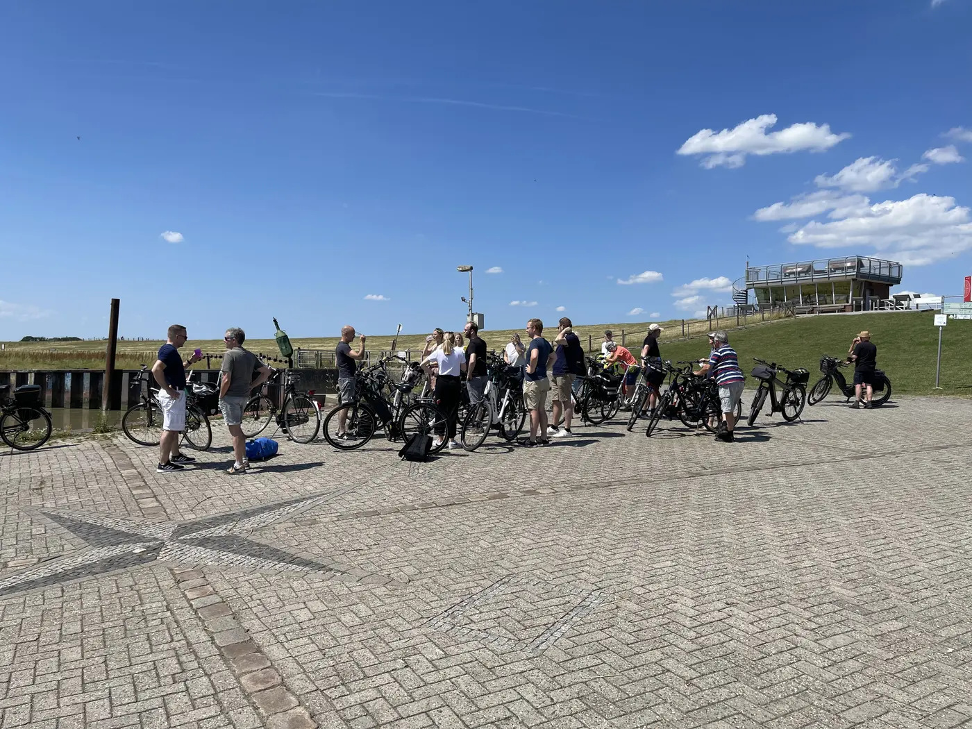 Eine Gruppe Radfahrer wartet mit ihren Rädern am Fähranleger