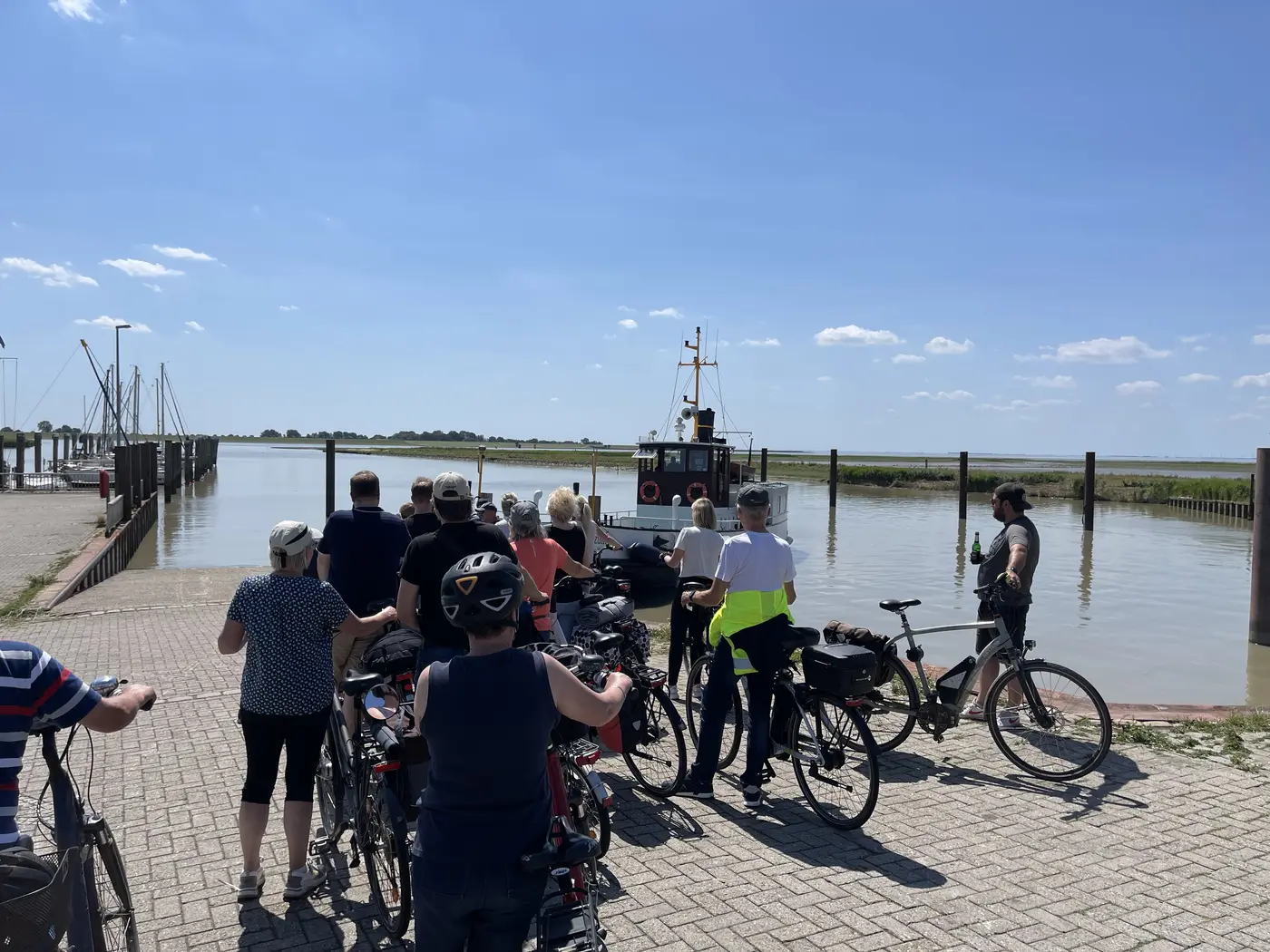 Radfahrer schieben ihre Räder Richtung Fähre